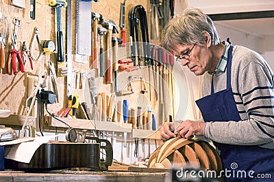 Instrument maker carving the body of a lute Stock Photo