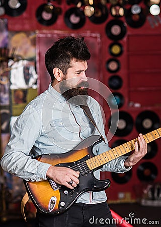 Instrumentalist concept. Musician with beard play electric guitar Stock Photo