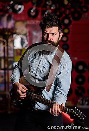 Instrumentalist concept. Musician with beard play electric guitar musical instrument. Stock Photo