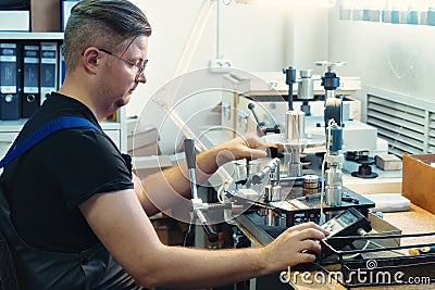 Instrumentation fitter performs equipment diagnostics and calibration at his desk Stock Photo