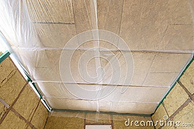 Insulated ceiling of a country house, insulation is closed with a vapor barrier film Stock Photo