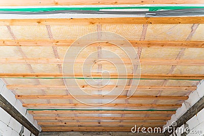 Insulated ceiling of a private house with a wooden crate. The roof is insulated with glass wool and sheathed with a vapor barrier Stock Photo