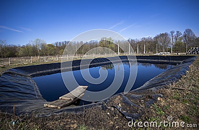 Insulated leachate pond with dirty water, part of landfill Stock Photo