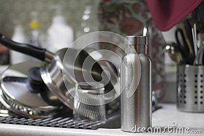 Insulated Stainless Bottle with utensils and sink kitchen background Stock Photo