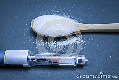 Insulin pen along with a tablespoon of white sugar Stock Photo
