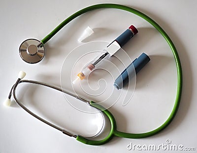 Insulin pen for diabetics with a green stethoscope around Stock Photo