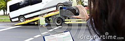 Insurance agent records accident on his phone and evaluates car. Stock Photo