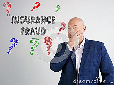 INSURANCE FRAUD question marks phrase on the gray wall Stock Photo