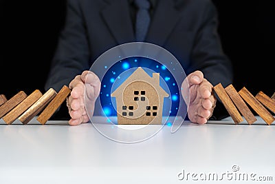 Insurance with hands protect a house. Home insurance or house insurance concept. The hand of a businessman protects the house from Stock Photo