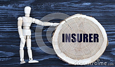 INSURER word on a wooden circle on a dark background with a male figurine Stock Photo