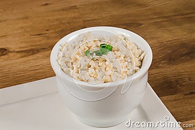Integral rice cooked in a white bowl. .Whole grain brown rice Stock Photo