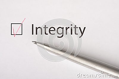 Integrity - checkbox with a tick on white paper with metal pen. Checklist concept Stock Photo