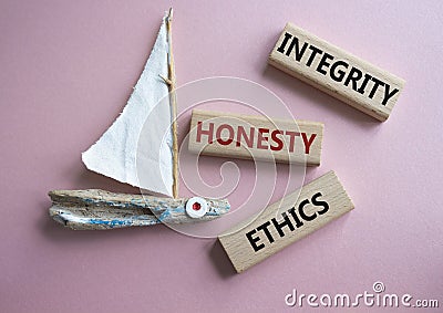 Integrity Honesty Ethics symbol. Concept words Integrity Honesty Ethics on wooden blocks. Beautiful pink background with boat. Stock Photo