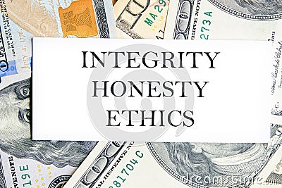 INTEGRITY HONESTY ETHICS text, a word written on a white business card against a background of money Stock Photo