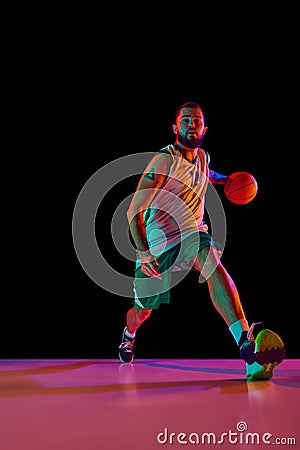 Intense concentration of basketball player during training session, emphasizing commitment to excellence against black Stock Photo
