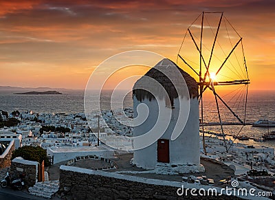 Intense sunset behind the famous windmill and the town of Mykonos island Stock Photo