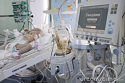 At the intensive care unit. Baby lying on a hospital bed attached to the reviving apparatus attached to the Editorial Stock Photo
