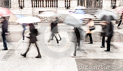 Intentionally motion blurred abstract image of commuters in a European city in a rainy day. Editorial Stock Photo