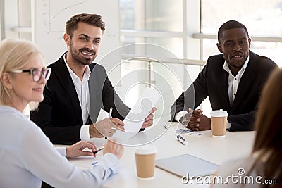 Interested diverse employees listen to colleague talking Stock Photo