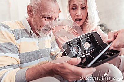 Interested occupied couple testing and uncovering VR glasses. Stock Photo