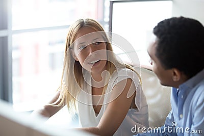 Young caucasian businesswoman manager listening to african colleague having discussion Stock Photo