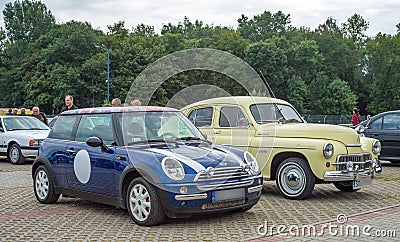 Elegant vintage old yellow Polish car Warszawa M20 and blue Mini Cooper parked Editorial Stock Photo