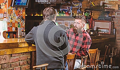 Interesting conversation. Hipster brutal bearded man spend leisure with friend at bar counter. Men relaxing at bar Stock Photo