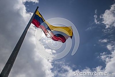 Interesting photograph of the flag of Venezuela waving in low angle with a sunny and cloudy sky Stock Photo