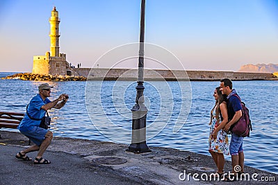 Interesting site of man taking photo of young couple in Chania Editorial Stock Photo