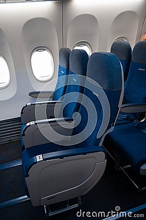 The interior of the aircraft. Empty airplane cabin. Rows of passenger seats with screens in the head restraints Editorial Stock Photo