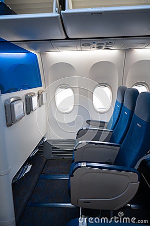 The interior of the aircraft. Empty airplane cabin. Rows of passenger seats with screens in the head restraints Editorial Stock Photo