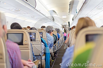 Interior of airplane with passengers on seats waiting to taik off. Editorial Stock Photo