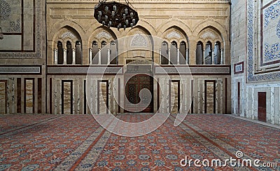 Interior of Al Rifaii Mosque Royal Mosque with big iron chandelier, decorated marble wall and ornate wooden door Editorial Stock Photo