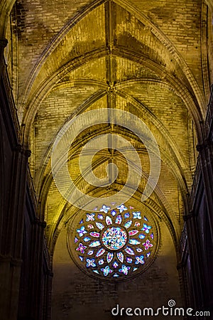 Interior arches and colored rose window of Sevilla Cathedral Editorial Stock Photo