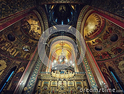 Interior architectural details of the Curtea de Arges monastery. The tall hall with painted icons, the golden altar and a Stock Photo