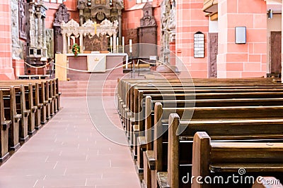 Interior of a beautiful old catholic church from below with marble floor, wooden pews, and light streaming onto altar Stock Photo