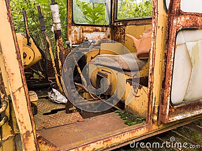 Interior of cabin with lever, joystick and seat of abandoned deserted old rusty bulldozer, vintage industrial heavy machine, Stock Photo