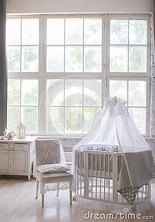 Interior of the children`s room, Provence style, oval baby cot, with canopy, light interior, large beautiful window Stock Photo