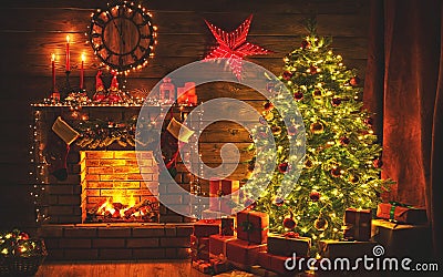 Interior christmas. magic glowing tree, fireplace gifts in dark Stock Photo