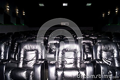 The interior of a cinema hall with black leather seats. The film does not show and no people Stock Photo