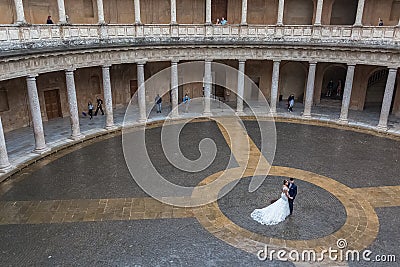 Interior circular Patio on Charles V Palace, wedding couple taking pictures on center at the Patio, Renaissance building located Editorial Stock Photo