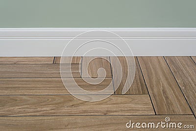 Interior concept. Light matte wall, white baseboard and tiles immitating hardwood flooring Stock Photo