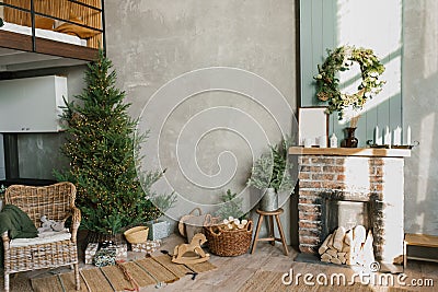 Interior of a country house with a fireplace, a Christmas tree, a wicker chair and decor for the new Year Stock Photo