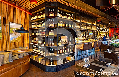 Interior of cozy luxury restaurant with original design and bottles of wine on the shelves Editorial Stock Photo
