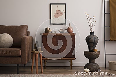 Interior design of cozy living room interior with mock up poster frame, brown sofa, sideboard, glass bottle, bowl with coconut, Stock Photo