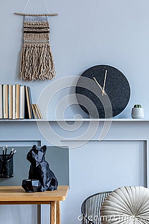 Interior design of home office room with wooden desk, armchair, plant, books, black clock and elegant personal accessories. Stock Photo