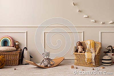 Interior design of kids room interior with wicker basket, yellow plaid, plush animal toys, wooden blockers, white garland, beige Stock Photo