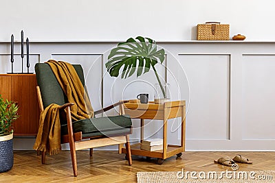 Interior design of stylish living room with vintage green armchair, wooden coffee table, furniture, grey wall, shelf, carpet. Stock Photo