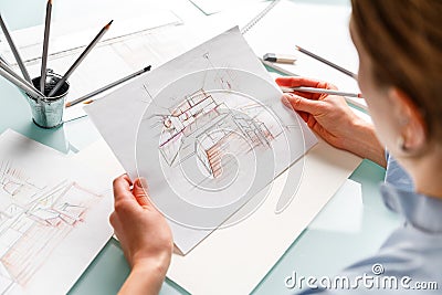 Interior designer holding pencil sketch of a kitchen in a process of drawing Stock Photo