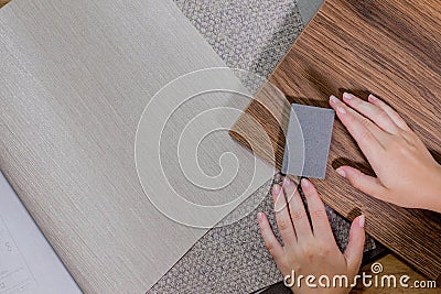 An interior designer's hand selects a palette of sample materials that includes different types Stock Photo